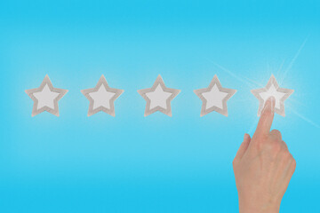 Female hand leaves a rating of five stars out of five possible on a blue background. Concept of...