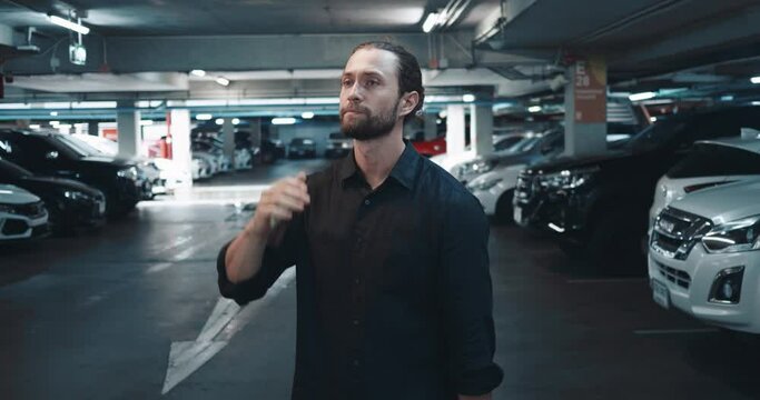 Person in underground parking lot is waiting for loved one and cannot contain his excitement. Man is very excited and worried that relative is late. Negative emotions arise from excitement of waiting.
