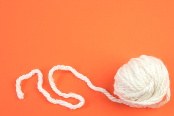 Knitting yarn for knitting on orange background. white.