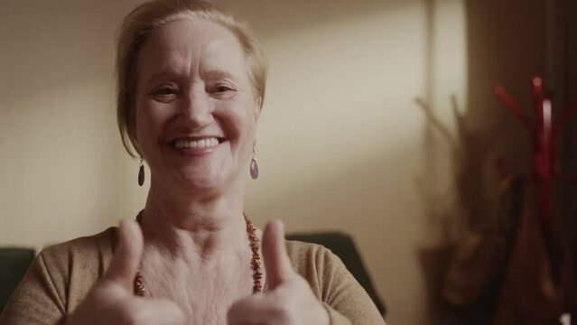 Alegre mulher s&ecirc;nior sorrindo sentada na cama pela manha. Cinematico 4k..