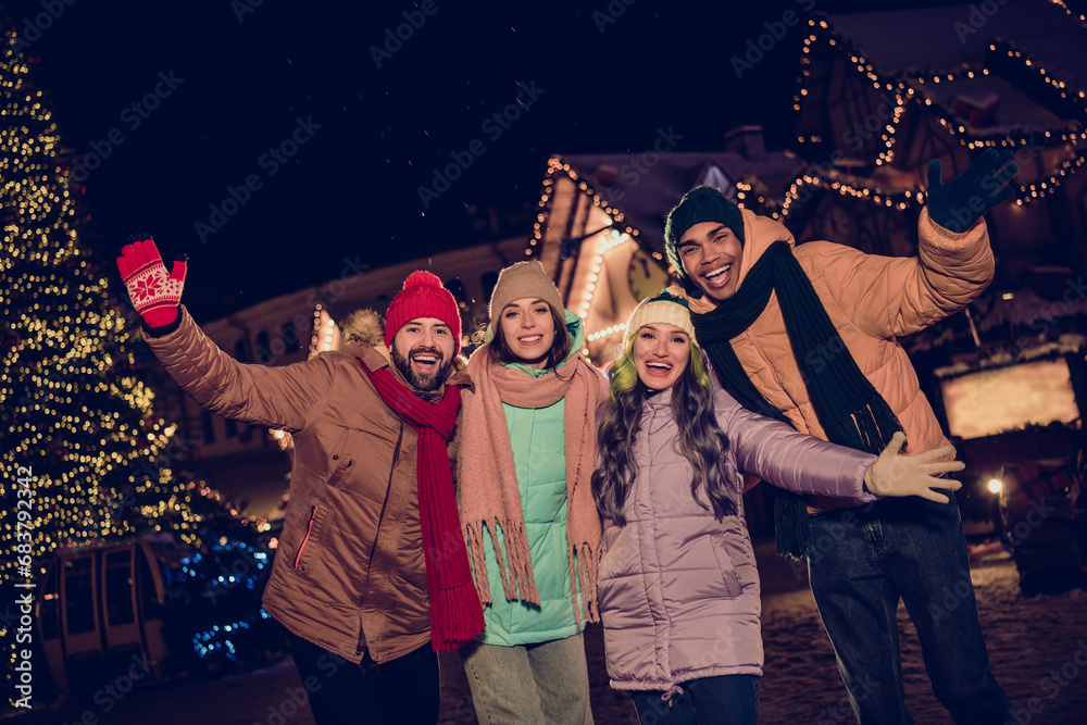 Poster Photo of funky funny two couples dressed coats celebrating x-mas rising hands arms together outdoors urban fair park