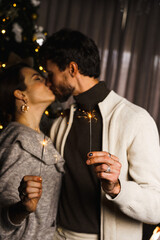 Happy family father, mother and son decorate the New Year tree, have fun, dance and unpack gifts. Christmas and New Years Eve concept. Vertical shot