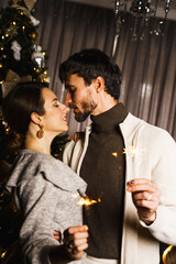 Happy family father, mother and son decorate the New Year tree, have fun, dance and unpack gifts. Christmas and New Years Eve concept. Vertical shot