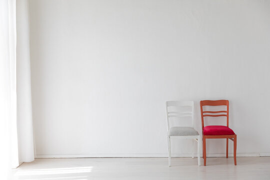 Two red and white vintage chairs in white room interior