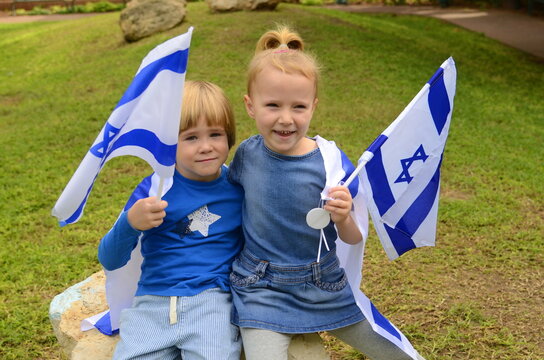 Children against the background of the Israeli flag. Israeli Independence Day, patriotism in kindergarten. Boy and girl