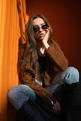 Beautiful young woman at sunset orange sun background