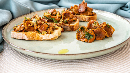 Bruschetta with pan fried chanterelle mushrooms with olive oil, onion, garlic, and dill on a green...