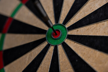 A dart arrow stick on the center of dart board. Bulls eye. Business goal concept.