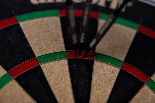 Three darts in triple twenty on professional sisal steeldart. Perfect 180 highscore shot dart game hobby sport concept background. 
