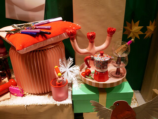 Gifts displayed in a store window  decorated for the end of year holidays, Christmas and New Year's Day : red items for home, dishes...