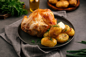 Portion of appetizing baked whole chicken with potatoes