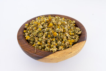 chamomile flower on a wooden plate isolated on a white background