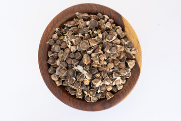moringa seeds on a wooden plate isolated on a white background
