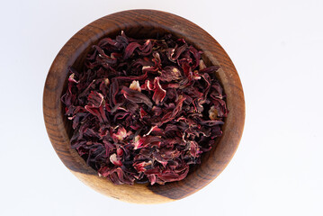 dry roselle leaves on a wooden plate isolated on a white background