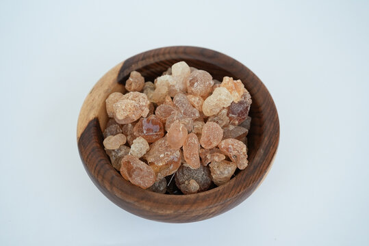 Fresh Gum Arabic on a wooden plate isolated on a white background
