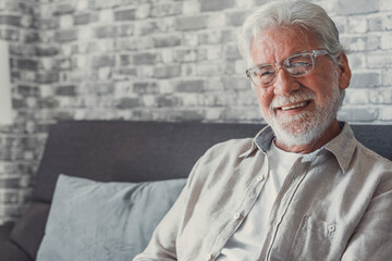 Portrait of happy mature 80s man sit on couch at home look at camera posing relaxing on weekend,...
