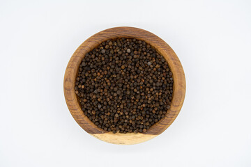 Nigella sativa seeds on a wooden plate isolated on a white background