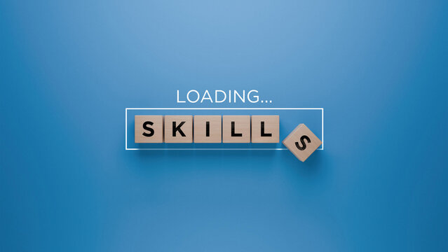 Wooden blocks spelling 'SKILLS' with a loading progress bar on a blue background, skill development and learning concept