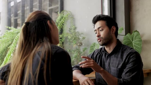 Asian worker relaxing free time after lunch in coffee shop, Asian freelancer and Indian employee business talking partnership running small restaurant shop owner, Asian and Indian couple discussing