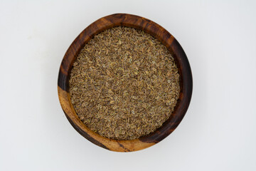 Dill seed falling on a white plate on a white background
