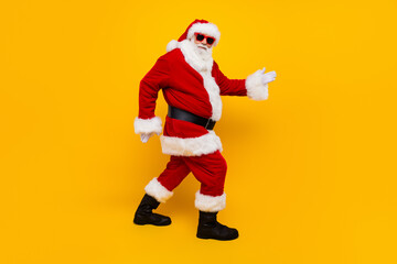 Full body profile portrait of positive eccentric aged santa walking magic new year time isolated on...