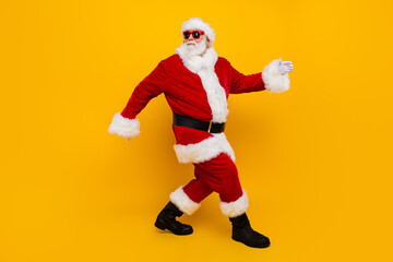 Fototapeta na wymiar Full body profile photo of charismatic aged santa walking empty space christmas ad isolated on yellow color background