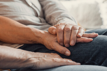Fototapeta na wymiar Close up elderly affectionate woman covering wrinkled hands of mature husband, showing love and support at home. Caring middle aged family couple enjoying sincere trustful honest conversation..