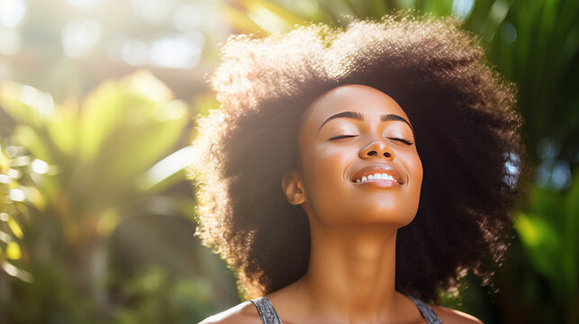 Headshot of a young African woman breathing fresh air in a hazy garden under the morning sun