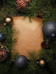 Christmas sheet of blank craft paper with copy space. frame of festive glittering blue baubles, ornament, fir tree  branches. New Year template for text, winter holiday concept. Top  view close up