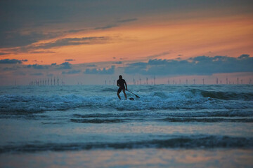 Surfer in the North Sea in the Netherlands at night