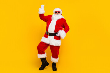 Fototapeta na wymiar Full body portrait of overjoyed satisfied santa raise fist success empty space christmas ad isolated on yellow color background