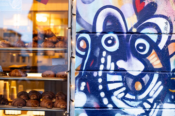 Croissants in the window of a bakery with mural
