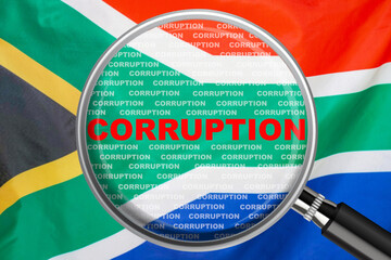 Loupe focused on the word corruption on South Africa flag background. Corruption, financial concept...
