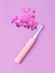 Pink electric toothbrush on lilac background. Toothbrush for girls