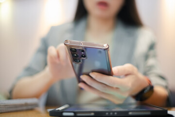 Beautiful woman wearing stylish glasses uses her phone to communicate with clients, corporate business venture.