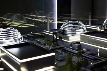 Scale model of a modern gray industrial building with a dome on the roof and backlighting