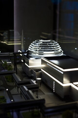 Future modern industrial building with lighting. Scale model of a house with a dome on the roof