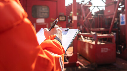 Maintenance engineer performs audit and inspection the power generator machine (as background) at the oil refinery plant working site. Industrial safety working wit people action, selective focus. - obrazy, fototapety, plakaty