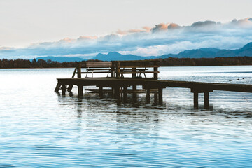 wooden pier with a bench at a lake