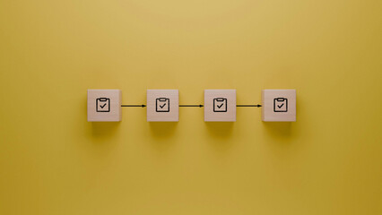 Task completion process with consecutive check mark symbols, stepwise project milestones achievement, to-do list verification illustrated with wooden blocks on a yellow background - obrazy, fototapety, plakaty