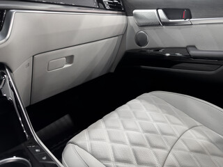 Car white leather interior. Part of white leather car seat details with white stitching. Interior...