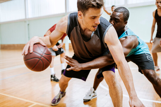 Intense Basketball Match Between Two Players on an Indoor Court