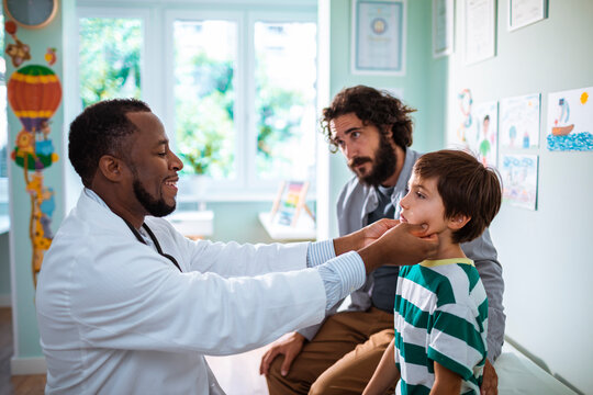 Doctor Performing a Throat Examination on a Child with Father Watching