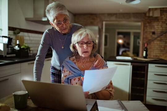 Senior lesbian couple going over bills and payments together at home
