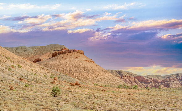 Witness the breathtaking romance of a desert sunset as the scorching sun bids farewell, casting a fiery explosion of color on the majestic Red Boguty Mountains. Sunset, love, desert atmosphere