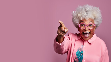 Happy senior afro woman points her finger at copy space for promotion - obrazy, fototapety, plakaty