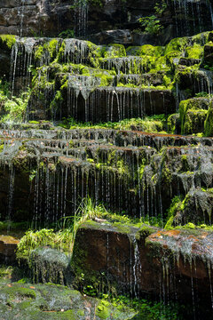The Tupavica waterfall on the Stara Planina mountain, village of Dojkinci, Serbia. Close up of amazing waterfall Tupavica on Old mountain, with vivid green moss, splashing water and red rocks.