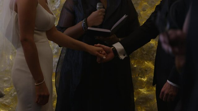 Bride and groom getting married - close up on hands holding at alter