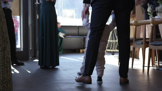 Father dancing with infant son at wedding reception - close up on feet