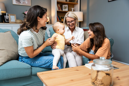 Happy family. Grandmother, mother, aunt and little baby having fun at home. Relatives visiting new born child.